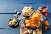 Apéro mit Chips, Snacks und Getränken auf einem blauen Holztisch Apéro mit Chips, Snacks und Getränken auf einem blauen Holztisch